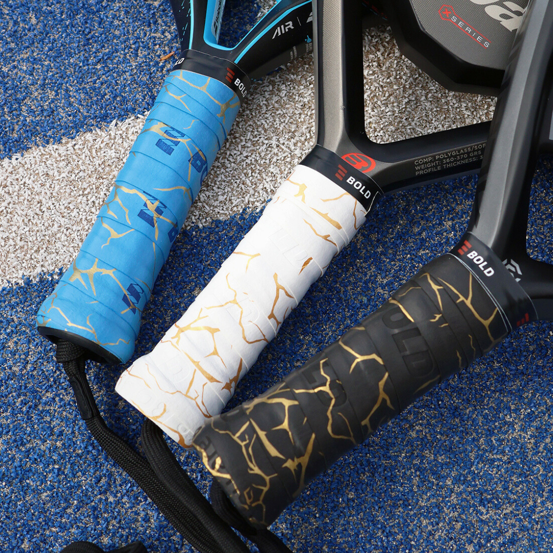 Three padel rackets with different handle designs on a textured surface