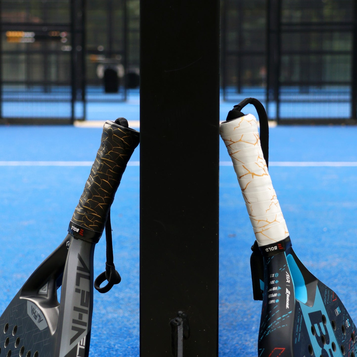 Two padel rackets with different grips on a blue court background