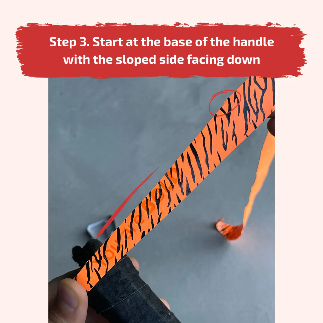 Applying the overgrip at the base of the padel racket handle